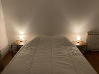 a bedroom with two lamps on two sides of a bed at Appartement Le Lauzet in La Roche-de-Rame