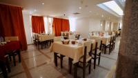 un ristorante con tavoli e sedie bianchi e tende rosse di New Sunset Resort a Aswan