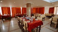 una sala da pranzo con tavoli, sedie e tende rosse di New Sunset Resort a Aswan