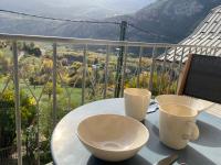 a table with two cups on top of a balcony at Appartement Le Lauzet in La Roche-de-Rame