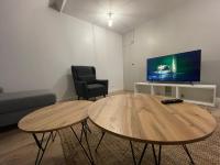 Televízia a/alebo spoločenská miestnosť v ubytovaní Les appartements d’Edgar
