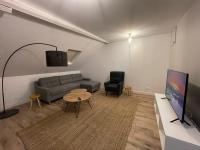 Televízia a/alebo spoločenská miestnosť v ubytovaní Les appartements d’Edgar