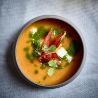 Un tazón de sopa con tocino y verduras en una mesa. en The Originals Boutique, Hôtel La Colonne de Bronze, Saint-Valéry-sur-Somme, en Saint-Valery-sur-Somme