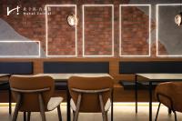 a dining room with chairs and a brick wall at Hotel Initial-Taichung in Taichung