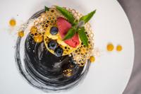 a plate with a dessert with fruit on it at Cyprianerhof Dolomit Resort in Tires