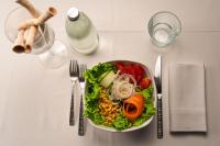 Fontaneto dʼAgognaにあるEmotional Grand Motelのテーブルの上にはフォークとナイフが置かれたサラダの皿がある