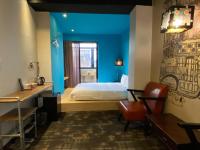 a bedroom with a bed and a blue wall at Cho Hotel in Taipei