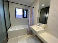 a bathroom with a tub and a sink and a bath tubermottermott at Cho Hotel in Taipei
