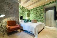 a bedroom with a bed and a chair at The Melegran in Rovinj