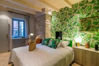 a bedroom with a bed with a green leafy wall at The Melegran in Rovinj