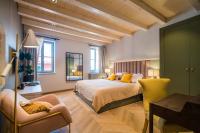 a bedroom with a large bed and a chair at The Melegran in Rovinj