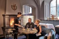 three people sitting around a table in a restaurant at Grand Resort Bad Ragaz in Bad Ragaz