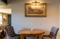 una mesa y sillas en una habitación con una foto en la pared en The Juniperlea Inn, en Pathhead