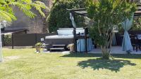 a garden with a hot tub and a table and a tree at Chambres d&#39;hôtes &amp; jacuzzi - A l&#39;ombre des amandiers in Saint-Martin-dʼArdèche