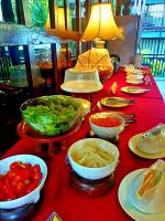 uma mesa com tigelas de comida numa toalha de mesa vermelha em Yantarasri Resort em Chiang Mai
