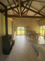 a living room with a stove and a table in it at Beautiful riverside boathouse in Bourg-Charente