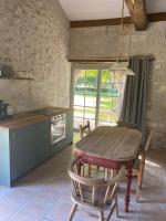 a kitchen with a wooden table and a table and chairs at Beautiful riverside boathouse in Bourg-Charente