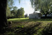 an old building in a field with a tree at Beautiful riverside boathouse in Bourg-Charente