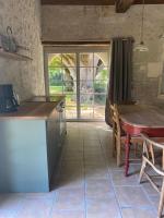 a kitchen with a table and a table and a window at Beautiful riverside boathouse in Bourg-Charente