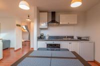 a kitchen with white cabinets and a table with chairs at Pleasant apartment three minutes from the center of Annecy in Annecy
