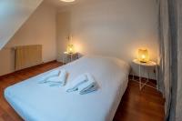 a bedroom with a white bed with two lamps on it at Pleasant apartment three minutes from the center of Annecy in Annecy