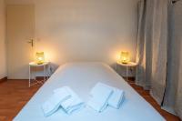 a bedroom with a white bed with two lamps on two tables at Pleasant apartment three minutes from the center of Annecy in Annecy