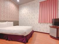 a bedroom with a bed and a tv in it at Centre Hotel in Kaohsiung