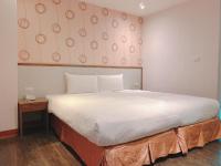 a bedroom with a large white bed and a table at Centre Hotel in Kaohsiung