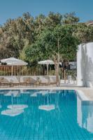 a swimming pool with chairs and umbrellas at Coralli Seaside Resort in Livadakia