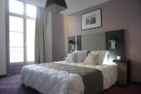 a bedroom with a large bed with white sheets and pillows at Odalys City Montpellier Les Occitanes in Montpellier