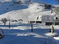 ein schneebedecktes Haus vor einem Berg in der Unterkunft Les Gourgs Blancs - Val Louron, vue sur pistes in Génos