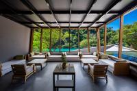 a living room with large windows and a table and chairs at Wulai Pause Landis Resort in Wulai
