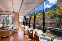 a restaurant with a view of the mountains through windows at Wulai Pause Landis Resort in Wulai