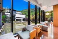 a living room with large glass windows and furniture at Wulai Pause Landis Resort in Wulai