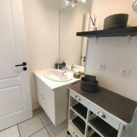 ein weißes Badezimmer mit einem Waschbecken und einem Spiegel in der Unterkunft Spacieux studio dans résidence avec parking privé in Clermont-Ferrand