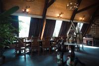 a dining room with tables and chairs and windows at LA SELVA Resort, Pench National Park in Khawāsa