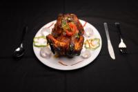 einen Teller mit einem Stück Fleisch und Gemüse in der Unterkunft AATHAVAN MATICHI ECO RESORT in Panhāla