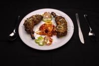 ein Teller mit Fleisch und Gemüse auf einem Tisch in der Unterkunft AATHAVAN MATICHI ECO RESORT in Panhāla