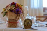 a table topped with a table number with a flower arrangement at Hotel Punta Est in Baja Sardinia