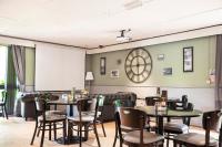 a dining room with tables and chairs and a clock at The Reston Hotel, Part of AG Collection in Washington