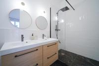 a bathroom with a sink and a shower and a mirror at Parisuites Central Grands boulevards Design Folies Bergères in Paris