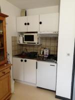 a kitchen with white cabinets and a microwave at petit nid montagnard in Rousset