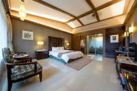 a bedroom with a bed and a living room at Great Roots Forestry Spa Resort in Sanxia