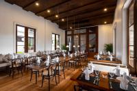 uma sala de jantar com mesas, cadeiras e janelas em Bella Nara Hotel Chiang Mai em Chiang Mai