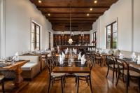 um restaurante com pisos e mesas e cadeiras de madeira em Bella Nara Hotel Chiang Mai em Chiang Mai