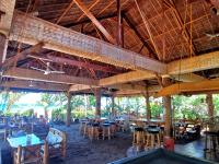 ein Restaurant mit Tischen und Stühlen und einer großen Decke in der Unterkunft Sulu Sunset Beach Resort in Nauhang