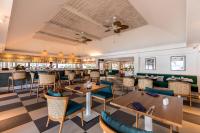 拉迈OUTRIGGER Koh Samui Beach Resort的一家有桌椅和酒吧的餐厅