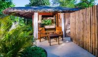 a patio with a table and chairs and an umbrella at Koh Jum Beach Villas "A member of Secret Retreats" in Ko Jum