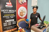 a woman standing next to a desk with a tennis racket at Legon City Mall Short Stay Apartments for Business and Vacation - East Legon in Accra