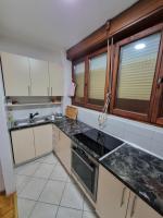 a kitchen with white cabinets and black counter tops at Apartman Danijela in Vukovar